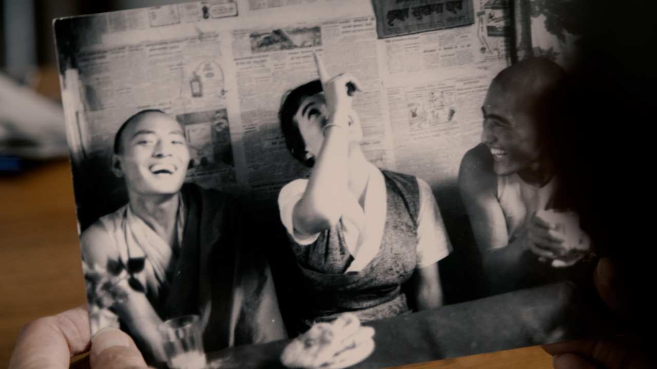 someone holding a vintage photo of 3 people